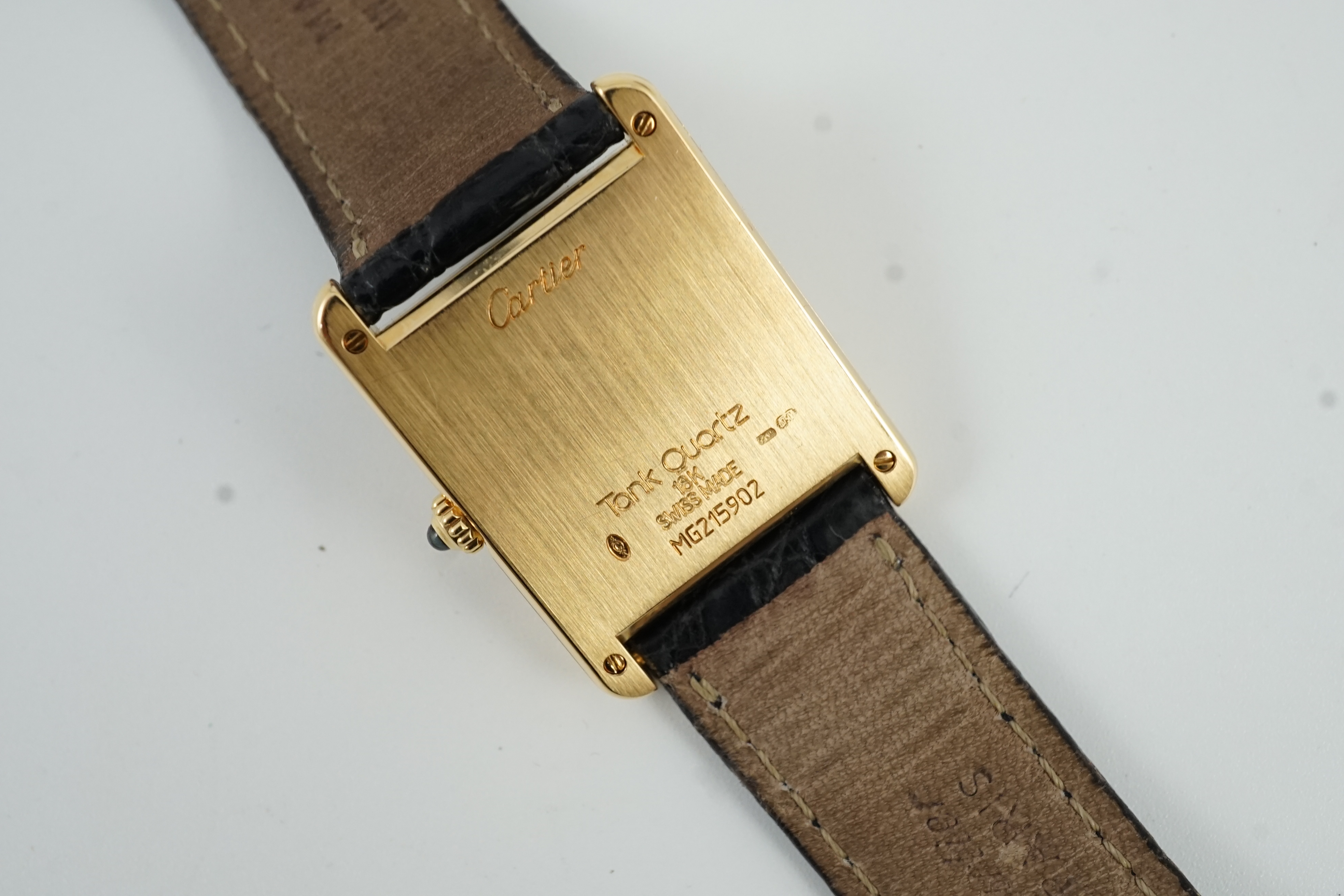 A gentleman's 18ct gold Cartier Tank quartz wrist watch, on a Cartier leather strap with Cartier 18ct gold buckle